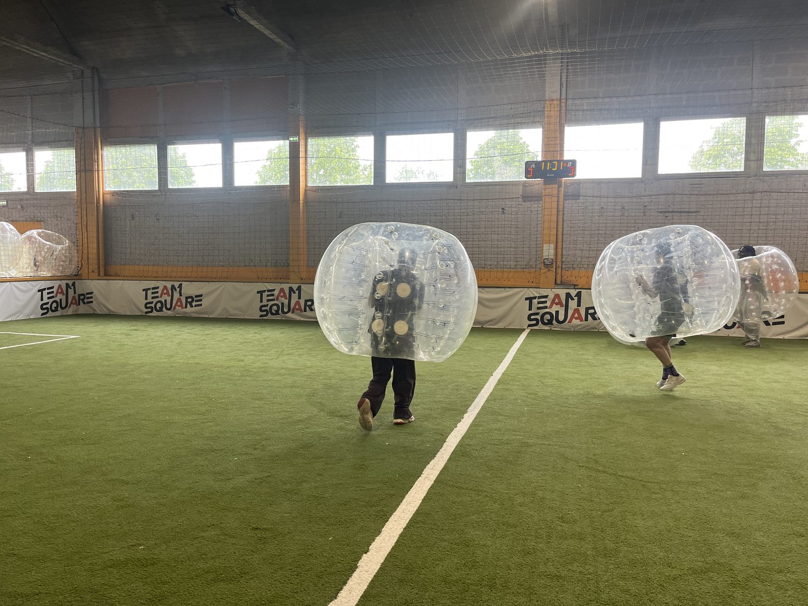 Deux joueurs de Bubble Foot se percutent sur le terrain chez Team Square